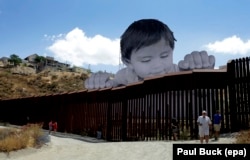 Инсталляция французского художника, выступающего под псевдонимом JR, установлена у барьера на границе Мексики и США в городке Текате