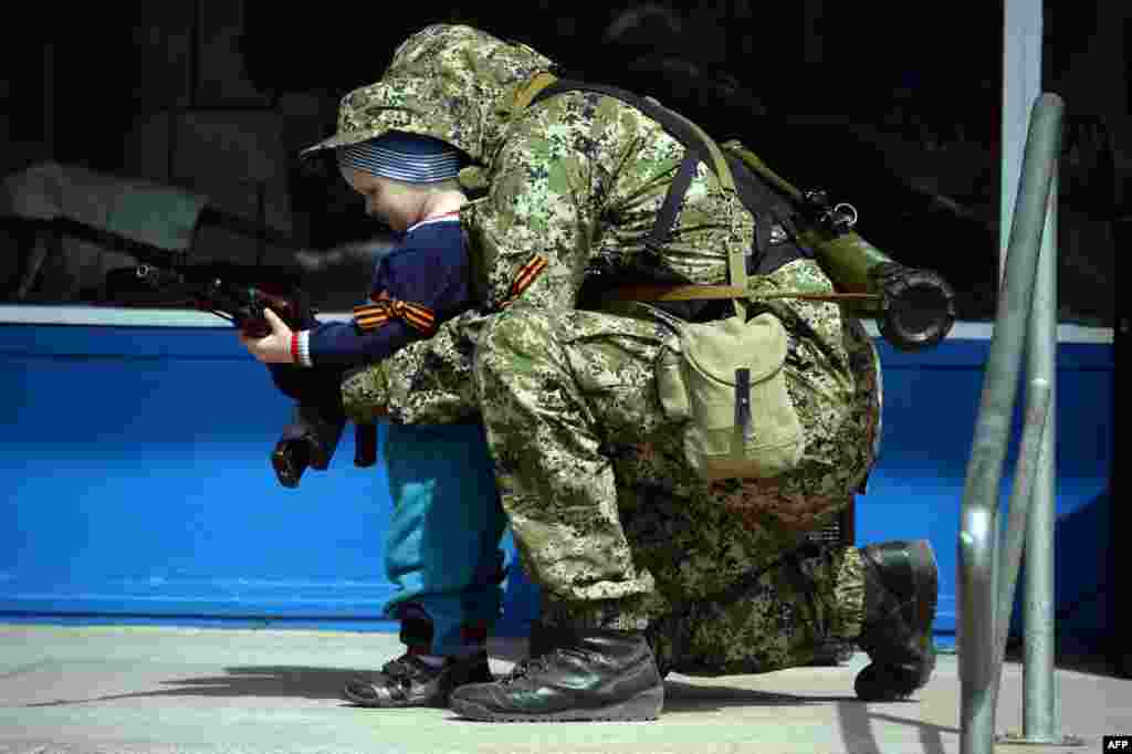Проросійський бойовик фотографується з дитиною біля захопленої будівлі міліції у Костянтинівці, 28 квітня 2014 року