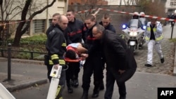 A victim is evacuated on a stretcher after armed gunmen stormed the offices of the French satirical newspaper Charlie Hebdo in Paris on January 7.