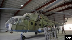 A U.S. Air Force soldier gives explanations to a group of Afghan translators for the Afghan National Army Air Corps on the Russian Mi-17 transport helicopter at a hangar in Kandahar air base in October 2009.