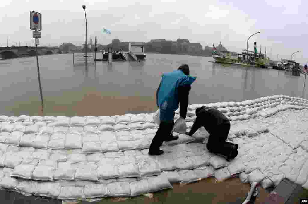 Two men pile sandbags in Dresden, Germany against imminent flooding from the Elbe River. (AFP/Arno Burgi)