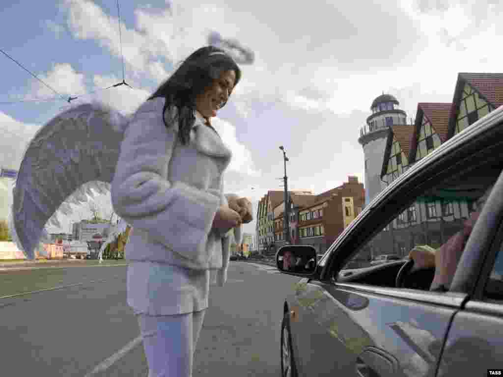 A Russian female traffic police officer dressed as an angel talks to a car driver in central Kaliningrad on the international day to commemorate traffic-accident victims on November 14. (ITAR-TASS/Yelena Nagornykh)