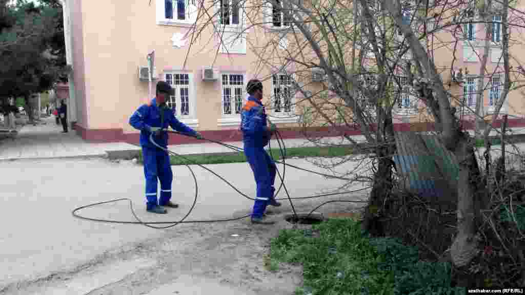 Aşgabatda kabel liniýalaryny çekýän işçiler.