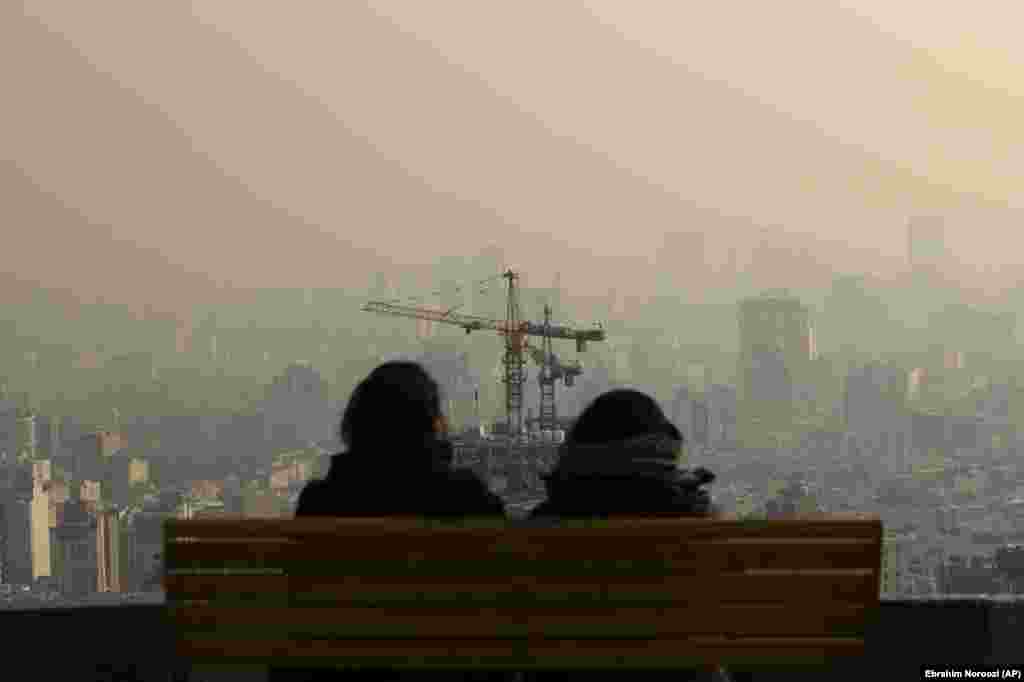 Two Iranians look out at Tehran&#39;s smoggy skyline on December 23. (AP/Ebrahim Noroozi)