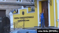 O angajata a Curții Constituționale dezinfectează ușa de la intrare, Chișinău, 12 martie 2020