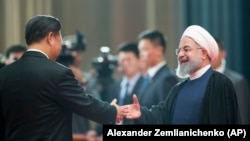 CHINA -- Chinese President Xi Jinping, left, greets Iranian President Hassan Rouhani at the Shanghai Cooperation Organization (SCO) Summit in Qingdao in eastern China's Shandong Province, Sunday, June 10, 2018