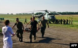 Soldați ucraineni cărând un camarad rănit.