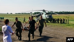 Украінскія вайскоўцы нясуць свайго параненага сябра 31 ліпеня 2014. Ілюстрацыйнае фота