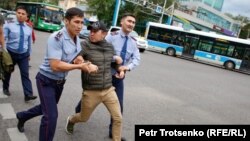 Полиция Олмаота шаҳри марказида митингда қатнашган йигитни ушлаб олиб кетмоқда. 2019, 12 июнь