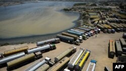 Грузовые автомобили и автоцистерны в пакистанском порту Карачи ожидают возобновления перевозок на север, к афганской границе. 