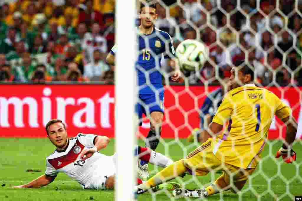 BRAZIL SOCCER FIFA WORLD CUP 2014 -- Germany's Mario Goetze (L) scores the 1-0 past Argentina's goalkeeper Sergio Romero (R) during the FIFA World Cup 2014 final between Germany and Argentina at the Estadio do Maracana in Rio de Janeiro, Brazil, 13 July 2