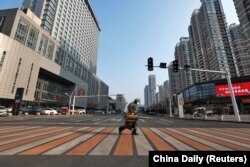 Një punëtor dezinfekton rrugën në qytetin Yichang të provincës Hubei. Shkurt, 2020. Gjatë kufizimeve si pasojë e pandemisë, Kina raportoi për zvogëlim të ndotjes së ajrit.