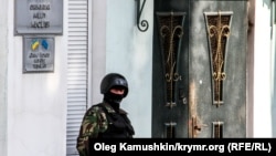 A file photo of a member of the local security forces standing guard outside the offices of the Crimean Tatar's Mejlis in Simferopol. The Tatar community on the Black Sea peninsula have complained of discrimination and harassment since the territory was forcibly annexed by Russia in 2014. 