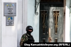 A file photo of a member of the local security forces standing guard outside the offices of the Crimean Tatar's Mejlis in Simferopol. The Tatar community on the Black Sea peninsula have complained of discrimination and harassment since the territory was forcibly annexed by Russia in 2014.