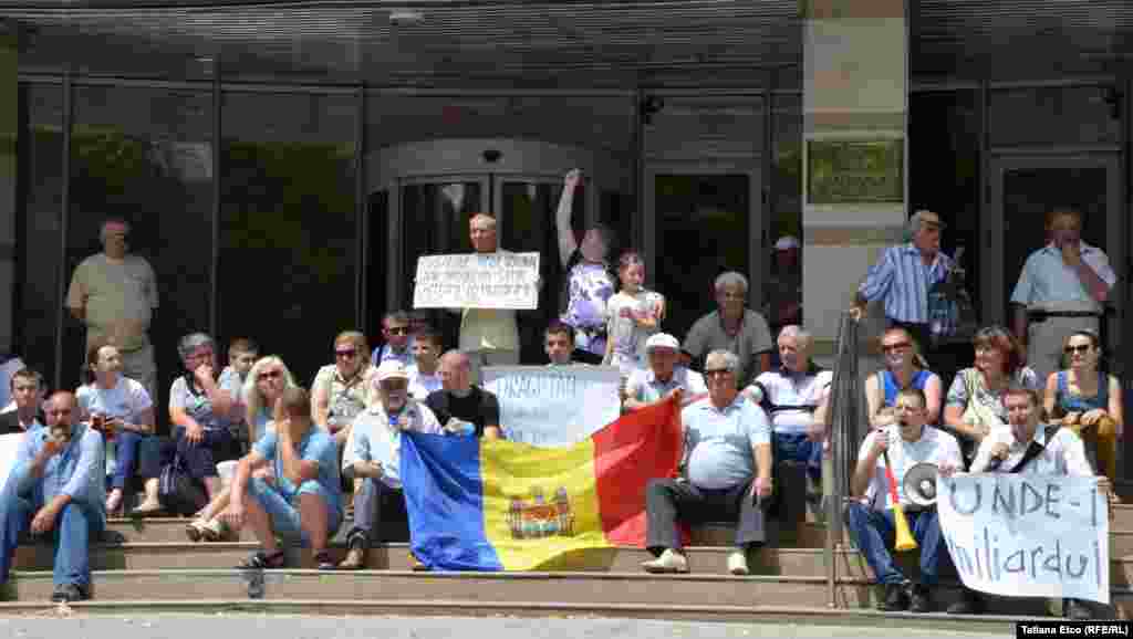 2 iulie 2015.&nbsp;Zeci de persoane au protestat în fața Băncii Naționale și au solicitat demisia guvernatorului Dorin Drăguțan, pe care îl acuză că ar fi complice la &quot;furtul secolului&quot;.