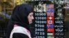 File photo - An Iranian woman walks past a currency exchange shop in the capital Tehran, April 24, 2019