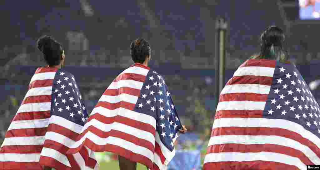 Third-placed Kristi Castlin (left to right), first-placed Brianna Rollins, and second-placed Nia Ali of the United States stand together after the women&#39;s 100-meter hurdles final.