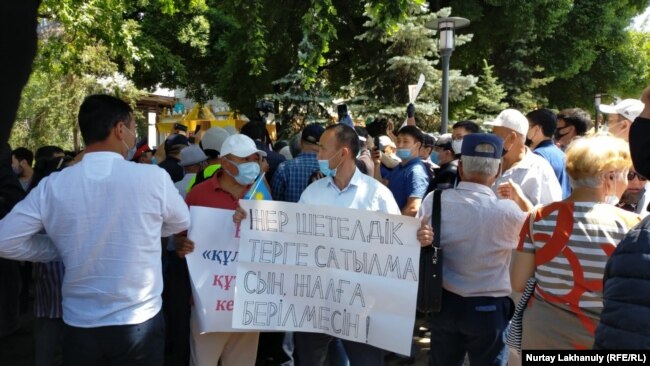 Протестующий с плакатом в Алматы. 6 июня 2020 года.
