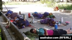 Kommunal hojalyk gullugynyň işgärleri yssy howada kölegede ýatyrlar (arhiw suraty)