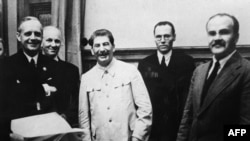 Министр иностранных дел Германии Иоахим фон Риббентроп (слева), заместитель госсекретаря Германии Фридрих Гаусс, глава советского государства Иосиф Сталин (3-й) и министр иностранных дел СССР Вячеслав Молотов (справа) позируют 23 августа 1939 года