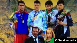 Жастар арасындағы әлем чемпионы Абылайхан Жүсіпов (ортада, көк киімде) тұғырда. София, Болгария, 24 сәуір 2014 жыл. (Жарыстың ресми сайтындағы видеодан скриншот). 