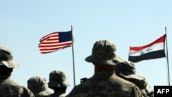 Trupe americane dau onorul steagurilor americane și irakiene (R) în timpul unei ceremonii de predare-primire în apropierea orașului Hawija din nordul Irakului, 15 mai 2011.