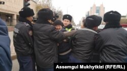kazakh activist Dulat Aghadil (center) being detained by police in Nur-Sultan on October 26.