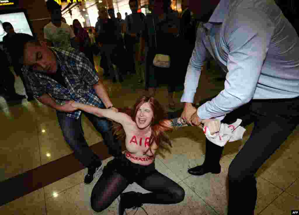 Activistă Femen care protesta împotriva premierului turc Recep Tayyip Erdogan arestată pe aeroportul Sabiha Gokcen din Istanbul, 5 iulie 2013.