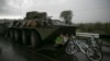 Ukrainian civilians find cover from the rain under a Ukrainian Army armored personnel carrier at a checkpoint near the town of Slovyansk on May 2. (Reuters/Baz Ratner )