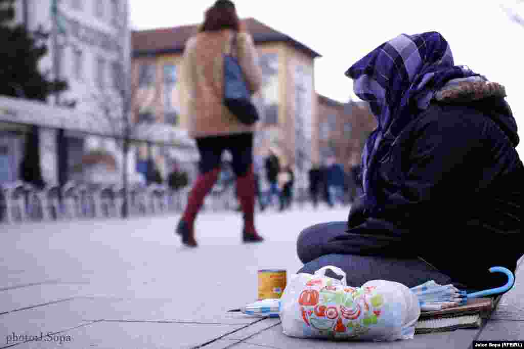 A beggar wrapped up against the chill in Mother Theresa Square in Prishtina. (Photo by Jeton Sopa)