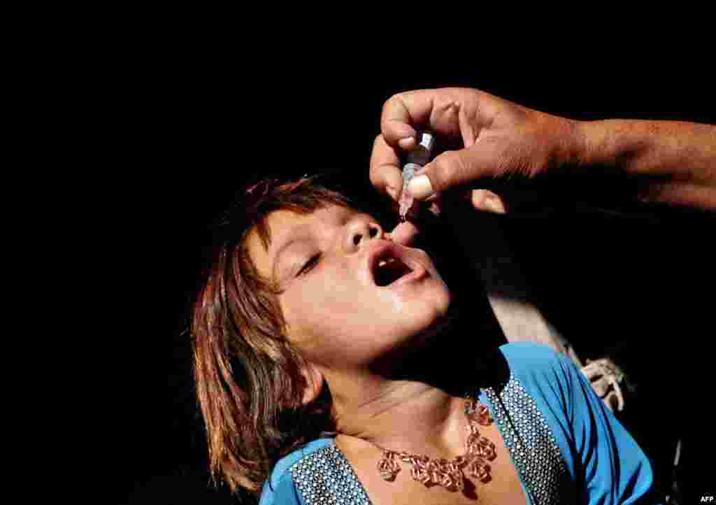 An Afghan health worker administers polio-vaccine drops to a child during the first day of a vaccination campaign on the outskirts of Jalalabad. (AFP/Noorullah Shirzada)