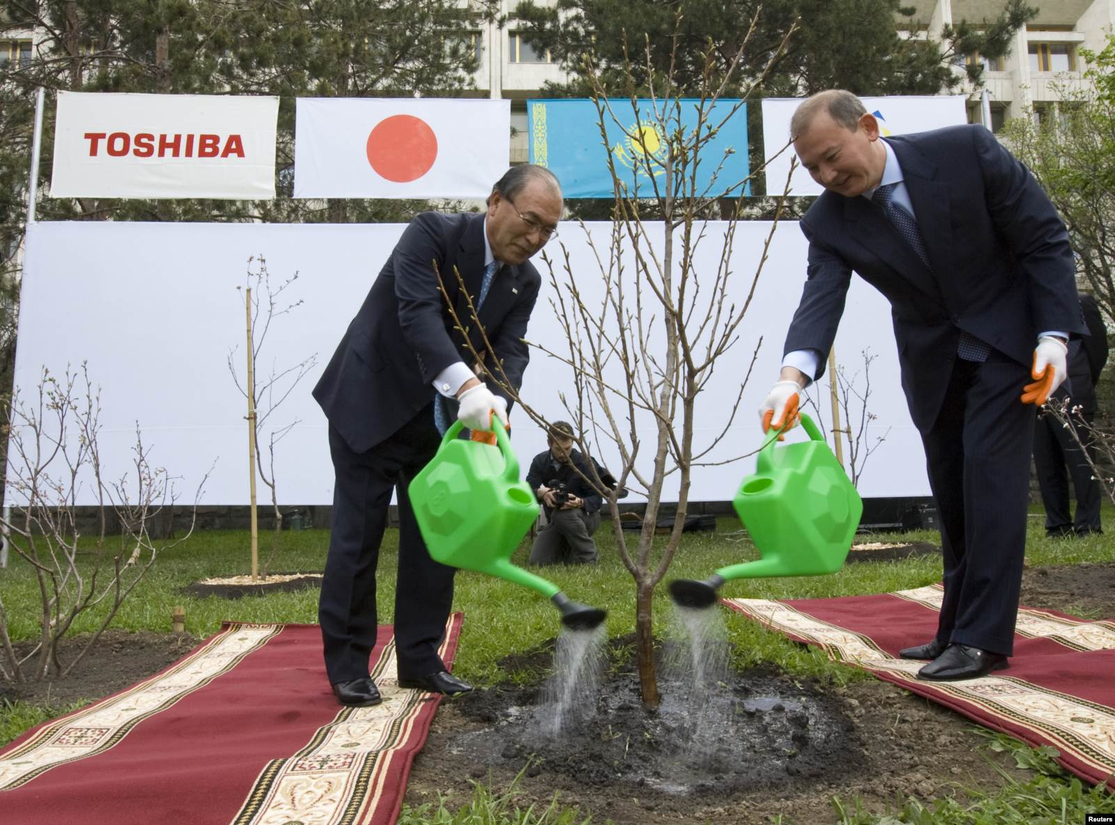 Мухтар Джакишев (справа) и президент Toshiba Corporation Ацутоши Нишида во время посадки саженца сакуры в Алматы. 25 сентября 2004 года.