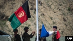 Afghan National Army soldiers raise their national flag next to the French flag during a transition ceremony at a base in Afghanistan in April.