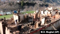 Kashmiris collect their belongings amid the debris of their homes that were reportedly destroyed by cross border shelling from Indian troops, in Neelum Valley, situated at the Line of Control in the Pakistani administered Kashmir on December 23.