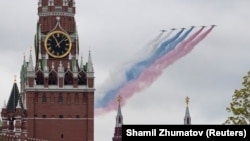 Российский реактивный самолет выпускает дым в цветах государственного флага России над Кремлевской стеной, иллюстрационное фото