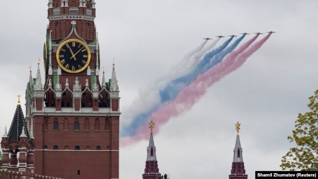 Российский реактивный самолет выпускает дым в цветах государственного флага России над Кремлевской стеной, иллюстрационное фото