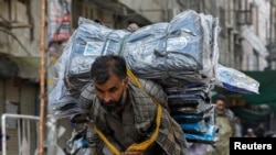 A laborer delivers packs of fabrics to a market during the lockdown in Karachi in May 2020.