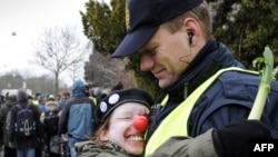 An activist wearing a red nose hugs a policeman during a protest in Copenhagen on December 16.