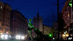 Жінка у центрі Харкова під час відключень світла у місті через масовані обстріли РФ, Україна, 14 квітня 2024 року