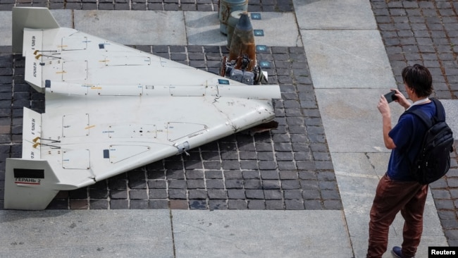 Відвідувач виставки фотографує частини іранського дрону «Шахед» 131/136, який був запущений по території України, Київ, 27 червня 2025 року