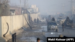 Afghan security forces gather at the site of a powerful truck bomb attack a day after it detonated near a foreign compound in Kabul on January 15.