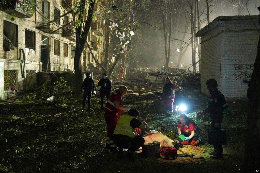 Mjekët ukrainas e mjekojnë një burrë të plagosur pas një sulmi me raketë balistike ruse në Kiev.