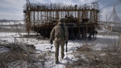 Український військовий в Донецькій області біля танка із протидроновим захистом