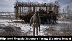 Український військовий в Донецькій області біля танка із протидроновим захистом