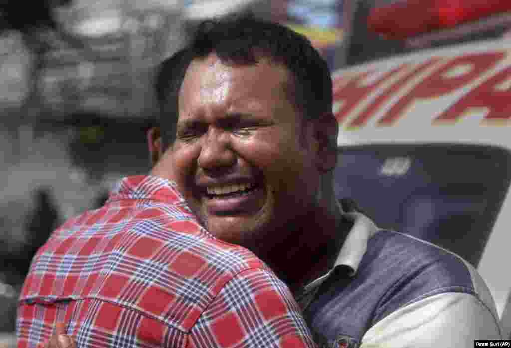 Një burrë pakistanez qan pasi një anëtar i familjes së tij vdiq nga zjarri në një fabrikë kimikatesh në Karaçi më 27 gusht.