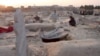 Afghanistan - An ethnic Turkmen family in northern Afghanistan was homeless and desperate -- so they took shelter in a cemetery alongside other destitute people. graves graveyard screen grab