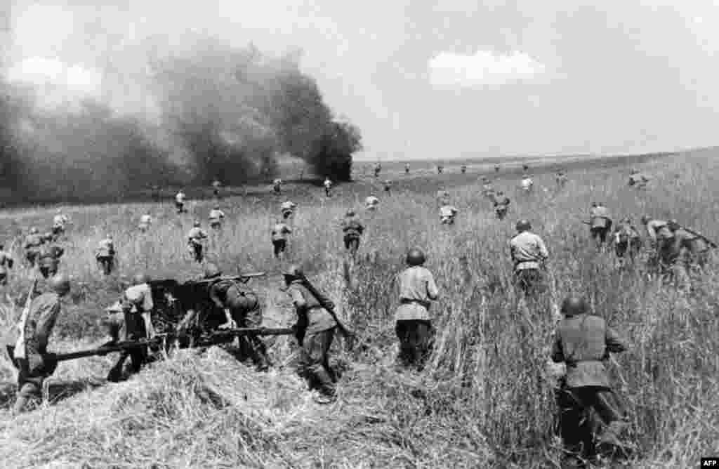 Unitățile Armatei Roșii avansează împotriva forței de invazie conduse de naziști într-o fotografie nedatată. Odată ce Stalin a ieșit din șocul său aparent și a preluat conducerea, luptătorii Armatei Roșii s-au confruntat cu mașina de război nazistă din față și comisarii politici din spate, care au fost autorizați să execute dezertorii la fața locului și să-și aresteze familiile.