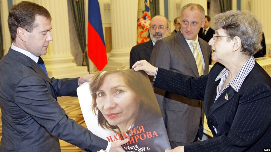 Human rights activist Svetlana Gannushkina gives Russian President Dmitry Medvedev a portrait of slain human rights activist Natalia Estemirova during a meeting at the Kremlin in Moscow in November 2009.
