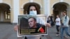 A woman in St. Petersburg holds up a poster in support of Aleksei Navalny, a popular Russian opposition leader whose poisoning on August 20 could leave him incapacitated for months. 