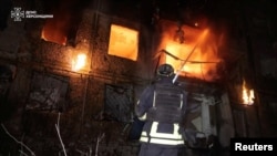 Өрт өчүрүүчү Орусиянын Украинага кол салуусу учурунда. Херсон шаарында Орусиянын аба соккусу болгон жерде иштеп жатат. Бул скриншот 2026-жылдын 17-октябрында жарыяланган видеодон алынган.